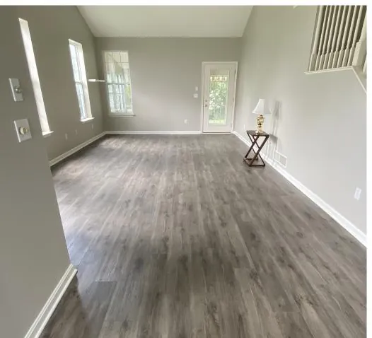 Living room with new gray vinyl plank flooring installed by Haven Builders