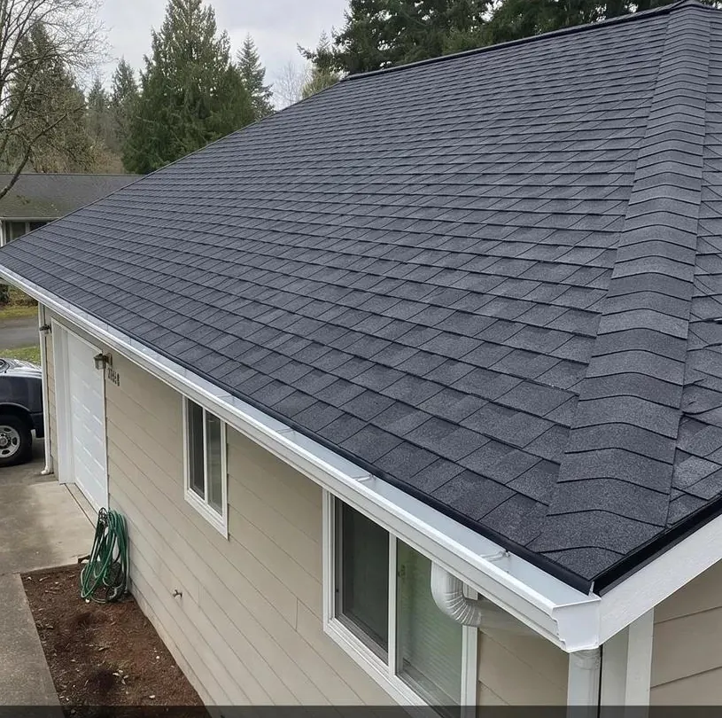 New asphalt shingle roof replacement with white gutters