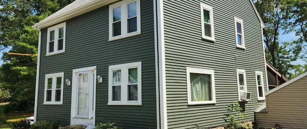 Siding replacement - home with new green vinyl siding and white trim