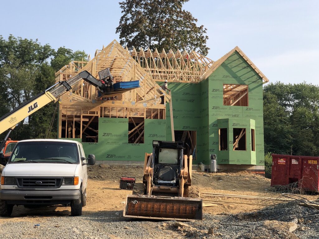 Wood-framed house under construction with studs, joists and sheathing visible